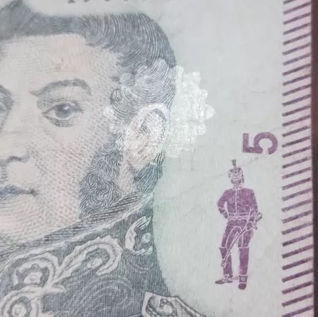 billete de $5 con el sello en la cara