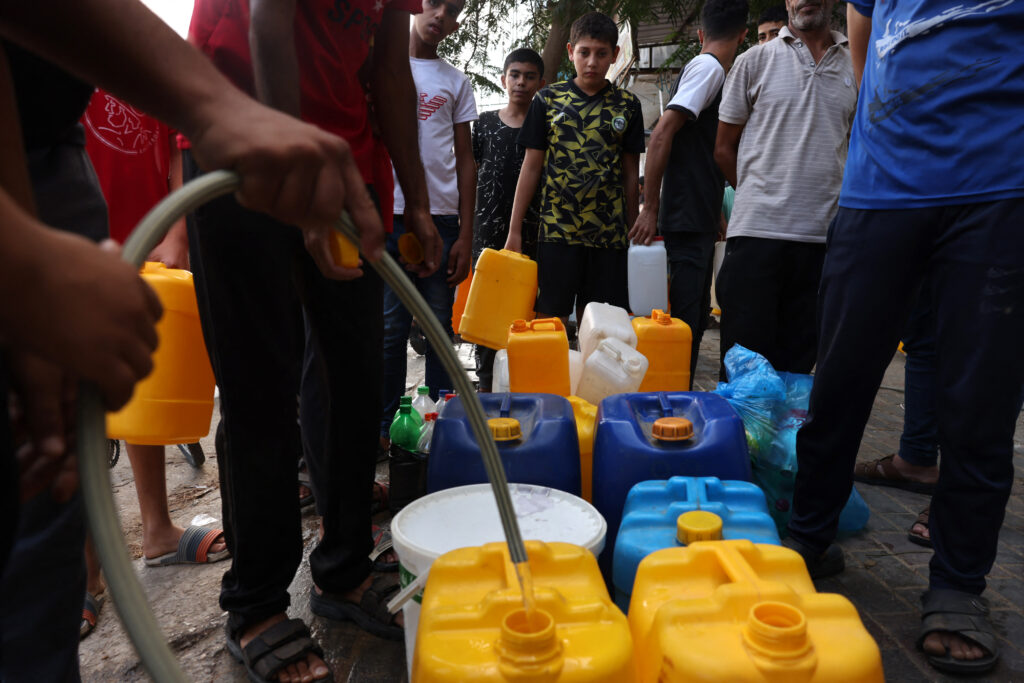 Palestinos hacen cola para recargar agua en el campo de refugiados de Rafah, en el sur de la Franja de Gaza.